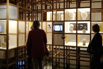 Museumsbesucher - im Hintergrund Ausstellungsobjekte