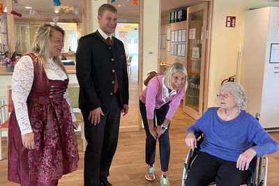 Einrichtungsleiterin Doris Frammelsberger, Bezirkstagspräsident Dr. Olaf Heinrich und dritte Bürgermeisterin Renate Wasmeier im Gespräch mit Bewohnerin Helga Krause, die launig aus ihrem Leben erzählte. 