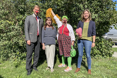 v. l.: Bezirkstagspräsident Dr. Olaf Heinrich, Elisabeth Makepeace-Vondrak, erste Vorsitzende der KlinikClowns, Clownin „Rosa Socke“ und Kulturreferentin Dr. Cindy Drexl