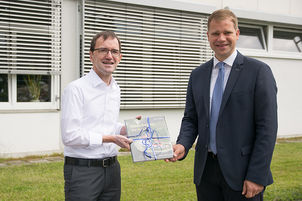 Bezirkstagspräsident Dr. Olaf Heinrich (r.) dankt Caritasdirektor Michael Endres mit Buchgeschenk.