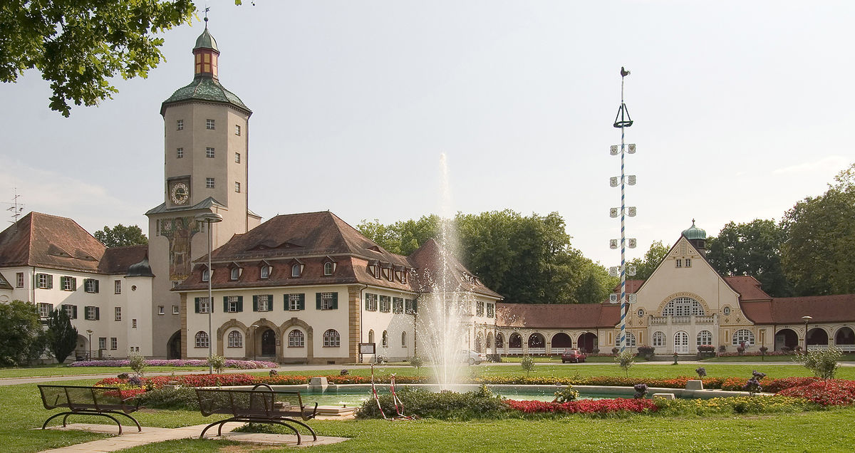 Das Jugendstilensemble des Bezirksklinikums Mainkofen mit Springbrunnen und Maibaum.