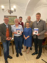 Bezirksheimatpfleger Dr. Maximilian Seefelder, Verleger Dr. Norbert Stellner, Akkordeonist Daniel Zacher, Dialektforscher Sammy El-Samahi, Schauspielerin Simone Bartzick und Bezirkstagspräsident Dr. Olaf Heinrich