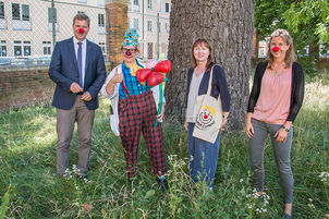 Clownin „Rosa Socke“ (2. v. l.) und Elisabeth Makepeace (3. v. l.), Gründerin der KliniClowns, besuchten Bezirkstagspräsident Dr. Olaf Heinrich (li.) in der Bezirksverwaltung in Landshut; Im Bild rechts Kulturreferentin Dr. Cindy Drexl.