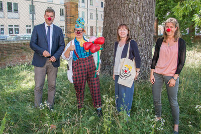 Clownin „Rosa Socke“ (2. v. l.) und Elisabeth Makepeace (3. v. l.), Gründerin der KliniClowns, besuchten Bezirkstagspräsident Dr. Olaf Heinrich (li.) in der Bezirksverwaltung in Landshut; Im Bild rechts Kulturreferentin Dr. Cindy Drexl.